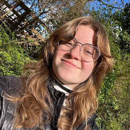 Esther-Adelson-crop.jpg Esther in front of trees and wooden fence